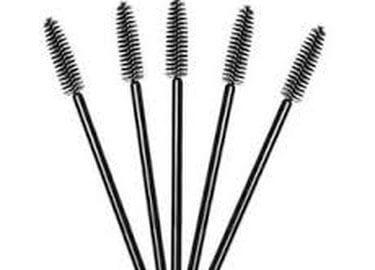A pack of professional disposable mascara brushes with black handles and high-density black bristles, shown alongside a model with perfectly groomed eyebrows.