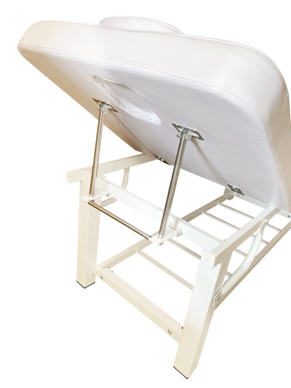 The Karma Napier Beauty Bed, featuring a raised backrest, removable face pillow, and a heavy-duty white steel frame with an integrated storage rack.